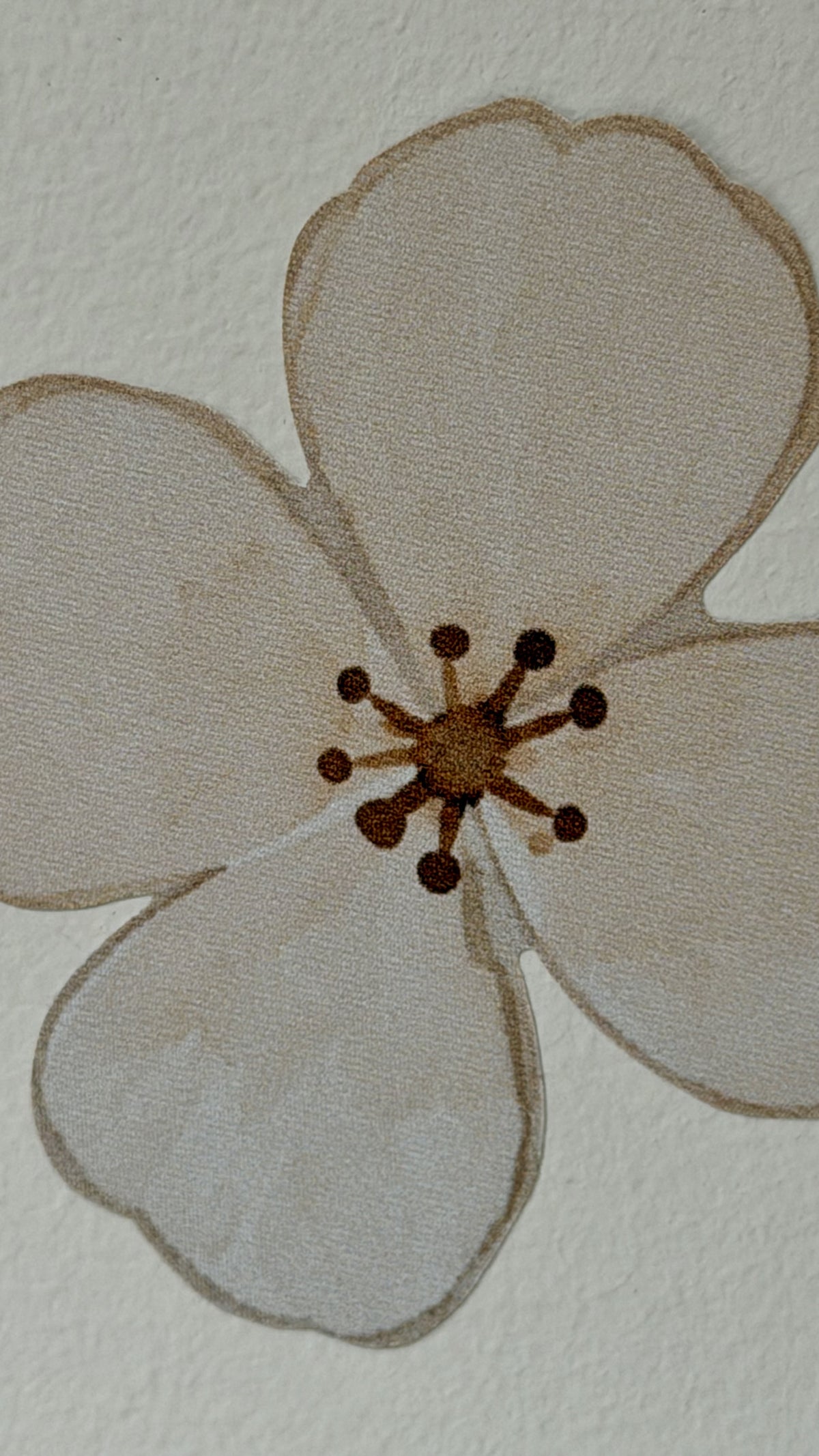 Close-up of an Ivory Bloom fabric wall decal featuring a delicate ivory flower with a warm brown centre and soft watercolour texture.