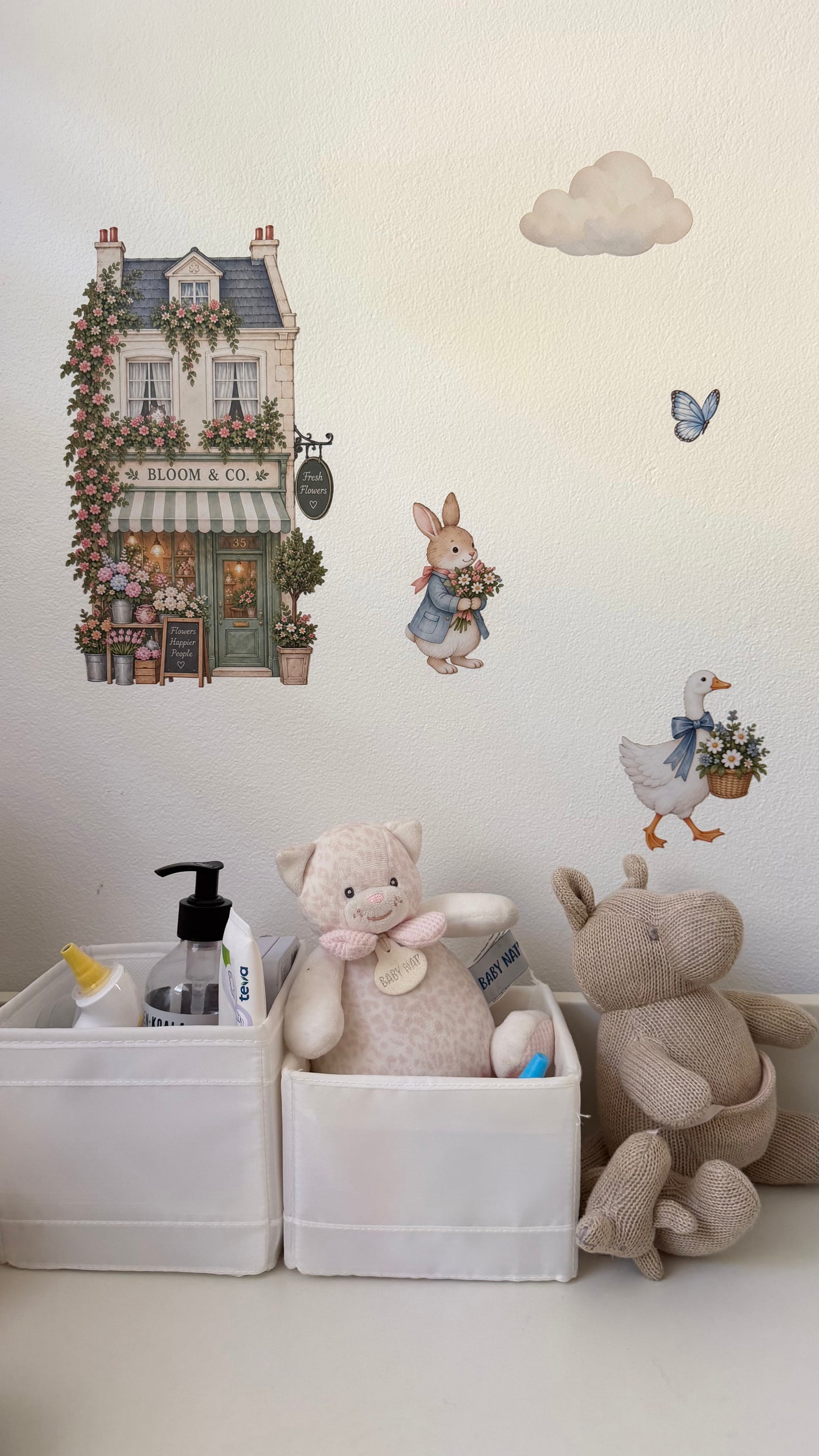Real nursery wall decorated with the London & Co flower shop decal, featuring a whimsical illustrated florist storefront.